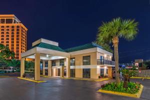 a building with a palm tree in front of it at Best Western Oak Manor in Biloxi