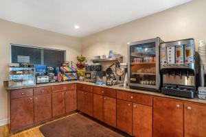 a kitchen with wooden cabinets and a refrigerator at Best Western Oak Manor in Biloxi
