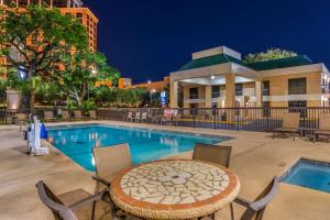 a pool with a table and chairs next to a building at Best Western Oak Manor in Biloxi