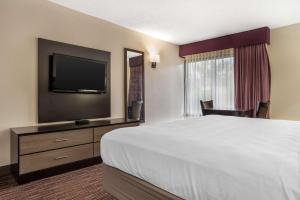 a hotel room with a bed and a flat screen tv at Best Western Oak Manor in Biloxi