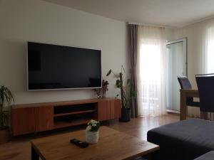 a living room with a flat screen tv on the wall at Sonnige 3 Zimmer Ferienwohnung Sun Mountain in Rechberghausen