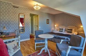 ストックホルムにあるスカンディック ガムラ スタンのベッド、テーブル、椅子が備わるホテルルームです。