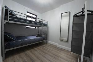 a room with two bunk beds and a mirror at THE WEE BELFAST HOUSE in Belfast