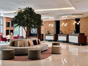 a lobby with a couch and a tree in the middle at Radisson Blu Hotel Krakow in Kraków