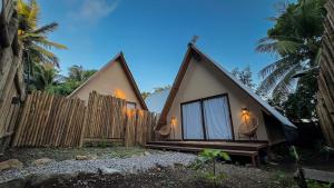 a small house with two large windows and a fence at Cabana Pitomba - Viagem Inspirada in Fernando de Noronha