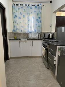 Vipingo Nomadic Apartment في Tezo: مطبخ مع مغسلة وموقد ونافذة