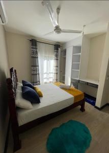 Vipingo Nomadic Apartment في Tezo: غرفة نوم بسرير كبير مع وسائد زرقاء