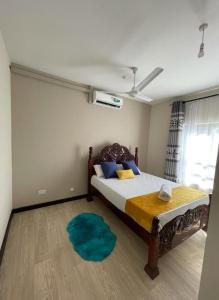 Vipingo Nomadic Apartment في Tezo: غرفة نوم بسرير وسجادة زرقاء