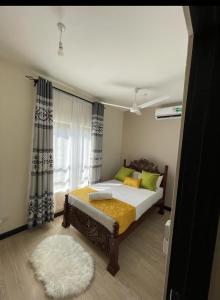 Vipingo Nomadic Apartment في Tezo: غرفة نوم بسرير ونافذة