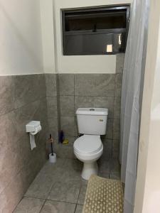 Vipingo Nomadic Apartment في Tezo: حمام صغير مع مرحاض ونافذة