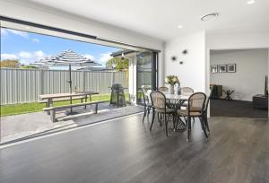 a dining room with a table and chairs and a patio at Havelock Holiday House in Havelock North