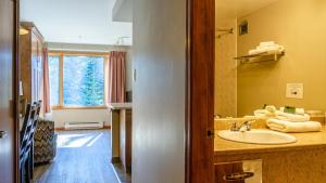 ein Bad mit einem Waschbecken und einem Spiegel in der Unterkunft Cahilty #357 home in Sun Peaks