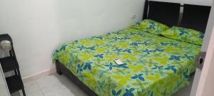 1 dormitorio con 1 cama con edredón amarillo y azul en Apartahotel, en Taganga