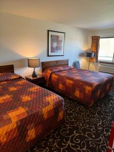 a hotel room with two beds and a window at Malibu Inn in Wisconsin Dells
