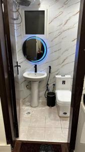 استديو العقيق في الرياض: حمام مع حوض ومرآة ومرحاض