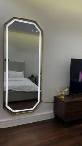 a mirror in a room with a bed and a tv at Studio Al Aqiq in Riyadh