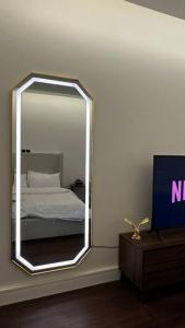 a mirror in a room with a bed and a tv at Studio Al Aqiq in Riyadh