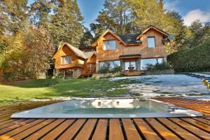 una casa con bañera de hidromasaje en una terraza de madera en Allá Ité en San Carlos de Bariloche