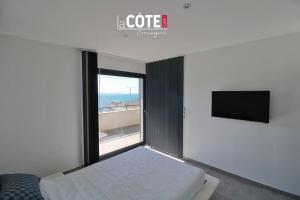 een slaapkamer met een bed en een raam met een tv bij Villa Maïa - 4 Couchages in Sausset-les-Pins