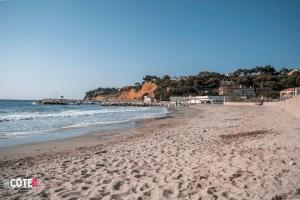een strand met voetafdrukken in het zand en de oceaan bij Villa Maïa - 4 Couchages in Sausset-les-Pins