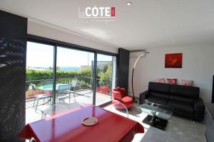 een woonkamer met een bank en een tafel bij Villa Maïa - 4 Couchages in Sausset-les-Pins