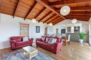 瓦南布爾的住宿－Hopkins View Holiday Home，客厅配有红色皮革沙发和桌子