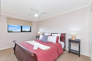 a bedroom with a large bed with a red blanket at Hopkins View Holiday Home in Warrnambool