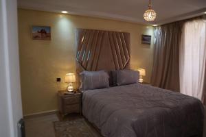 Luxurious & panoramic views في مراكش: غرفة نوم بسرير كبير ومصباحين