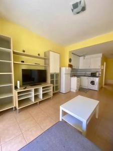 sala de estar con mesa blanca y cocina en Placer Junto al Mar: Vívelo!, en Las Palmas de Gran Canaria