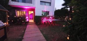 uma casa com luzes roxas na frente em Nassali - Beautiful Villa in Tamaris em Casablanca