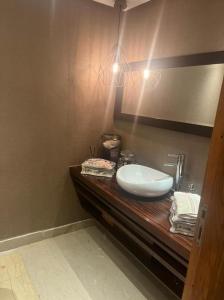 a bathroom with a white sink on a wooden counter at Nassali - Beautiful Villa in Tamaris in Casablanca