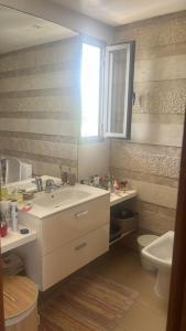 Nassali - Beautiful Villa in Tamaris في الدار البيضاء: حمام مع حوض ومرحاض ومرآة