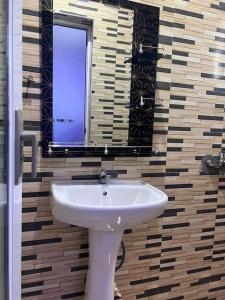 a bathroom with a white sink and a mirror at Adnan lodge in Tamale