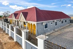 um edifício com um telhado vermelho e uma cerca em Adnan lodge em Tamale