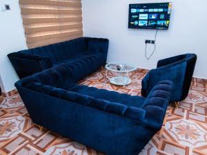 two blue couches in a living room with a table at Adnan lodge in Tamale