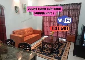 Homestay Kota, Kuala Terengganu FREE WIFI في كوالا ترغكانو: غرفة معيشة مع أريكة وطاولة