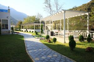 ein Garten mit einem Pavillon, einem Tisch und Stühlen in der Unterkunft Jolnar garden hotel in Macka