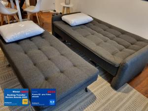 two beds sitting in a living room with price signs at PRESNO 01- piso 9 bien ubicado in Montevideo