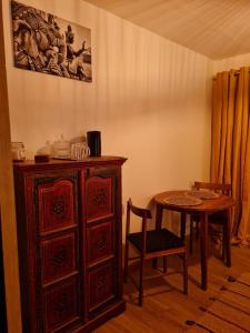 ein Esszimmer mit einem Tisch und einem Holzschrank in der Unterkunft Home Gãyatri in Angé