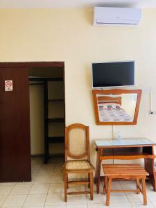 Habitación con escritorio, silla y TV. en Hotel Rex Ciudad Valles en Ciudad Valles