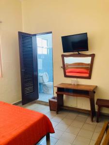 - une chambre avec un lit, un miroir et une télévision dans l'établissement Hotel Rex Ciudad Valles, à Ciudad Valles