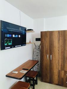 a room with a table and a tv on a wall at Suite Hermosa ven descansa o trabaja El Rodadero Santa Marta in Gaira