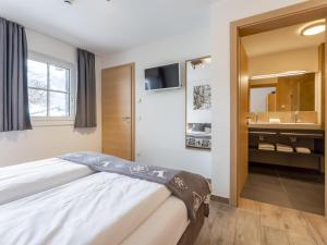 a bedroom with a bed and a sink and a mirror at Luxury Tauern Suite Walchen Kaprun 1 in Piesendorf