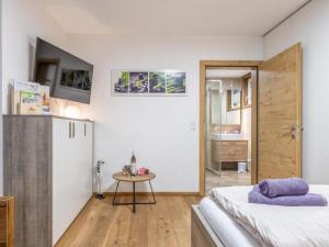 a bedroom with a small table and a refrigerator at am Waldrand in Wörgl