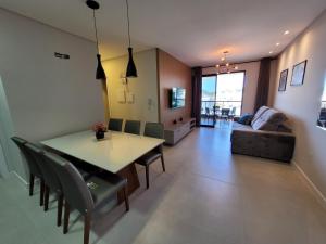 a dining room and living room with a table and chairs at Recanto Dos Girassois 408 in Bombinhas +13 photos