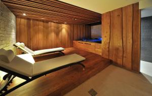 a room with a sauna with a bench and a tub at Via Jasna Wellness Apartments in Liptovský Mikuláš