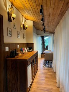 a kitchen with a wooden counter top and a table at Estalagem Serra de Minas em Monte Verde in Monte Verde