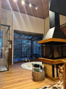 an open living room with a fireplace and a tub at Estalagem Serra de Minas em Monte Verde in Monte Verde