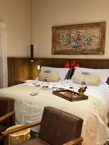 a bedroom with a large bed with flowers on it at Estalagem Serra de Minas em Monte Verde in Monte Verde