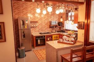 a kitchen with a refrigerator and a counter top at Casa NR 2 Hospedaria in Tiradentes